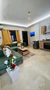 马拉喀什Luxury apartment Gueliz (2 min walk from Train Station)的客厅配有绿色沙发和桌子
