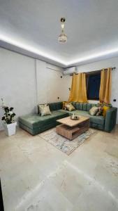 马拉喀什Luxury apartment Gueliz (2 min walk from Train Station)的客厅配有绿色沙发和茶几
