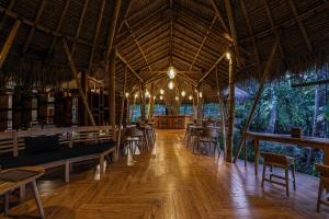珀尼达岛Bila Penida Resort & Farm的一间带桌椅的餐厅,铺有木地板