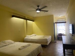 库尔克岛SKY INN的一间卧室配有两张床和吊扇