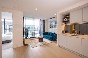 墨尔本The Marker Apartments Melbourne的厨房以及带蓝色沙发的起居室。