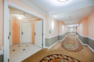 拉斯维加斯MGM Signature Towers, Balcony Suite, Strip View - NO RESORT FEES!的走廊上设有橙色的墙壁和白色的门,地毯