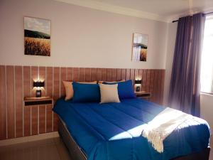 德班1205OnTheGoldenMile - 4 Sleeper Ocean View with Pool & Braai at 10 South的一间卧室配有蓝色的床和2个床头柜