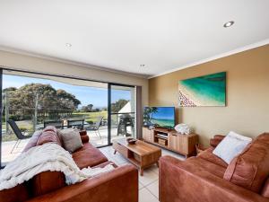 梅林布拉Seachange Apartments Merimbula的客厅配有两张沙发和一台电视机
