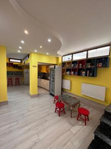 巴统Hostel Jeal的厨房设有黄色的墙壁、红色的椅子和桌子