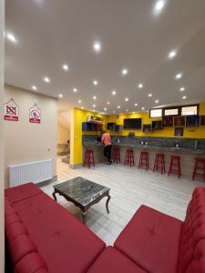 巴统Hostel Jeal的一间设有红色沙发的等候室和一间酒吧