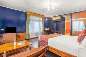 佩林Summit Tashi Ghang Heritage Resort的酒店客房配有一张床铺、一张桌子和一张书桌。