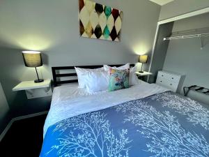 坎莫尔加拿大落基山小屋酒店的一间卧室配有一张带两盏灯的蓝色和白色的床。