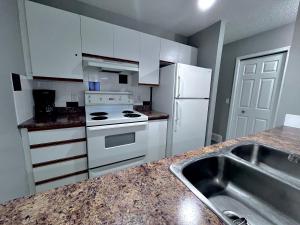 坎莫尔加拿大落基山小屋酒店的厨房配有白色家电和水槽