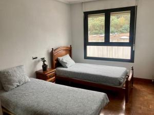 阿拉萨特-蒙德拉贡Luminosa habitación的一间卧室设有两张床和窗户。