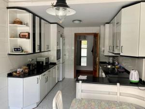 阿拉萨特-蒙德拉贡Luminosa habitación的厨房配有白色橱柜和黑色台面