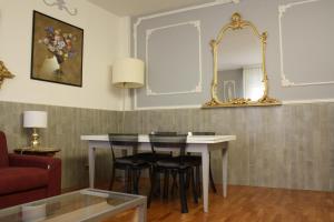 博洛尼亚Appartamento blu centro storico的一间带桌椅和镜子的用餐室