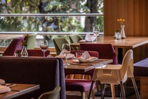 林格瑙阿德尔酒店的配有桌椅和酒杯的餐厅
