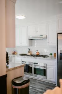 大贝尔城1998-The Ranch House home的厨房配有白色橱柜和炉灶烤箱。