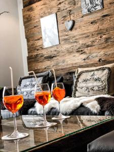 采尔马特全景滑雪公寓式酒店的坐在沙发前的桌子上,三杯酒