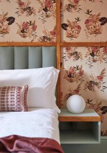 KentThe George & Heart House的一间卧室配有一张带花卉壁纸的床