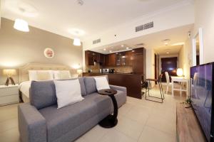 迪拜Prime Retreats- Downtown Dubai的一间卧室配有一张床和一张沙发,还设有一间厨房
