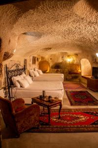 于尔居普石窟艺术酒店的一间洞穴卧室,配有两张床和一张桌子