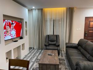 卢萨卡Meanwood Place Apartments的带沙发和电视的客厅