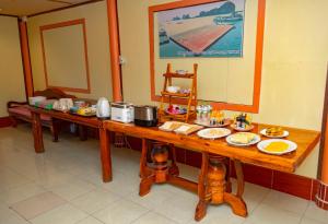 Ko PanyiJamesbond Bungalow Koh Panyee的一张长木桌子,上面放着食物盘