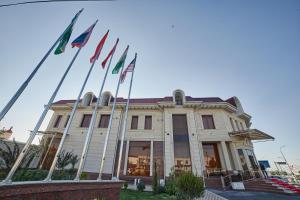撒马尔罕Comfort Hotel Samarkand的前面有旗帜的建筑