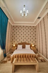 撒马尔罕Comfort Hotel Samarkand的一间卧室配有一张大床和一个吊灯。