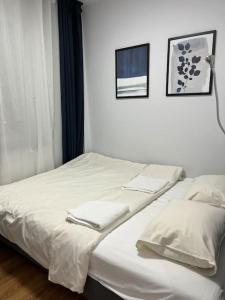 弗罗茨瓦夫Komfortowe apartamenty w centrum Wrocławia的配有2张床的客房内配有白色床单和毛巾