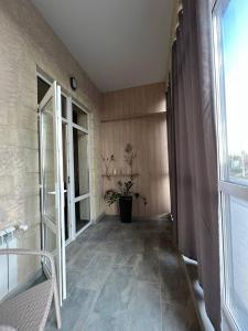 PrilimanskoyeSilveroks Apartment的走廊上设有大玻璃门和植物