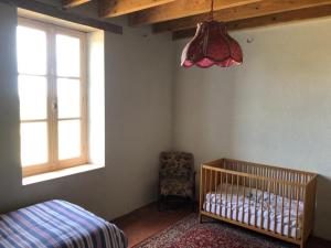 圣迪兹尔Le Tarde - Crécerelle的一间卧室设有一张婴儿床和一扇窗户。