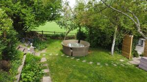 奇彭纳姆Log Cabin near Bath的花园,草地上设有大浴缸