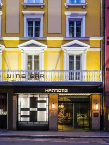 斯特拉斯堡HANNONG Hotel & Wine Bar的黄色建筑前方的商店,带阳台