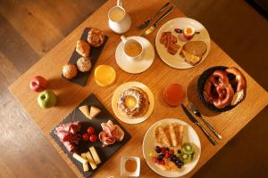 斯特拉斯堡HANNONG Hotel & Wine Bar的一张木桌,上面放着早餐食品