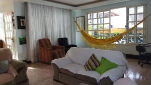 萨尔瓦多Diversão, churrasco e piscina - Praia de Ipitanga的带沙发和吊床的客厅