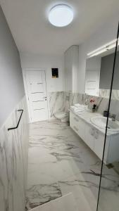 萨图马雷Magic Mirror的白色的浴室设有水槽和卫生间。