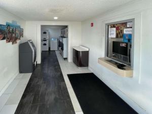 黑格斯敦Motel 6 Hagerstown MD的客房设有带冰箱和电视的走廊。