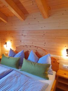 巴特霍夫加施泰因Haus Schwaiger的一间卧室配有一张带蓝色和绿色枕头的床