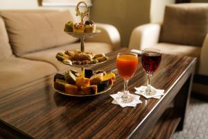 达曼La Rive Hotels & Suites的一张桌子,上面放着一盘食物和两杯葡萄酒