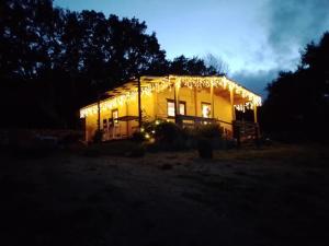 CalangianusEco Lodge nella natura "La Grande Quercia"的夜晚点亮的房屋,灯火在里面