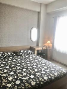 万隆秀波莱特2号公寓的一间卧室配有一张带黑白花卉床罩的床。