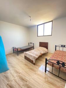 马达巴Apartment in madba的带三张床和窗户的客房