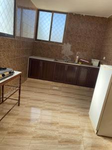 马达巴Apartment in madba的厨房配有木制橱柜和瓷砖地板。