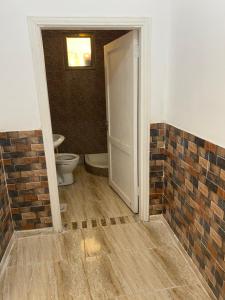 马达巴Apartment in madba的开放式浴室设有卫生间和砖墙