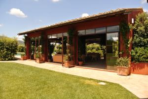 卡帕尔比奥洛坎达罗萨酒店的一座带玻璃门和草坪的房屋