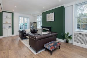 伦敦The London House - Entire Villa的客厅设有真皮沙发和壁炉