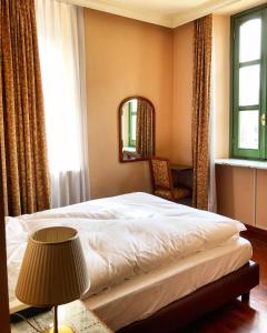 塞斯托拉Hotel Roma的一间卧室配有床、镜子和灯