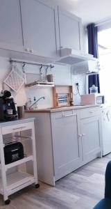 拉罗什波赛Bienvenue au 8 Bis的厨房配有白色橱柜和台面