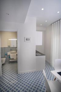 索伦托Domus Sole的浴室铺有蓝色瓷砖地板,拥有白色的墙壁。