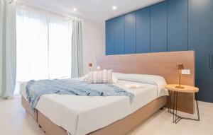 莱乌卡Villa Agape Luxury Leuca by HDSalento的一间卧室配有一张带蓝色墙壁的大床