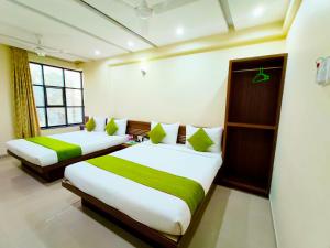舍地SAI SRUSHTI by NEEM SQUARE的绿白色客房内的两张床