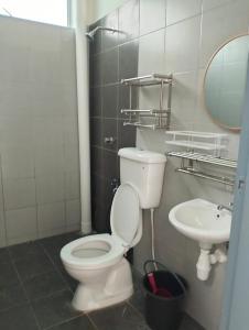 日得拉Mahzan Homestay的一间带卫生间和水槽的浴室